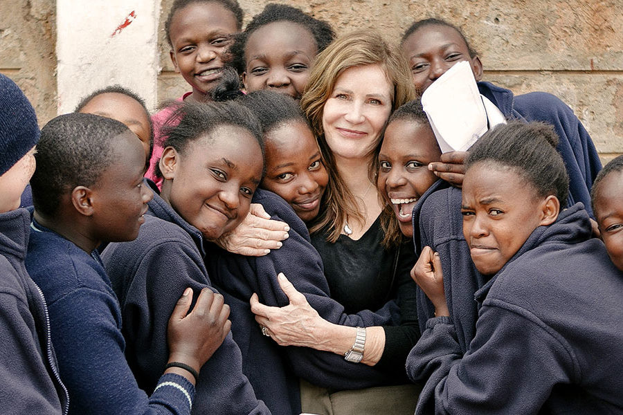 Lotte Davis surrounded by Kenyan girls of her program One Girl Can teaching self-confidence to future women leaders