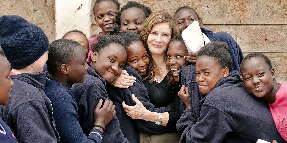 Lotte Davis surrounded by Kenyan girls of her program One Girl Can teaching self-confidence to future women leaders
